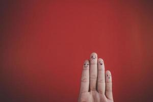 Finger mit Emotion auf rotem Hintergrund.