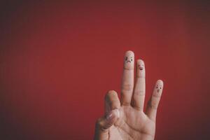 Finger mit Emotion auf rotem Hintergrund. foto