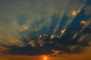 schöner Himmel mit Wolken und Sonnenstrahlen bei Sonnenuntergang foto