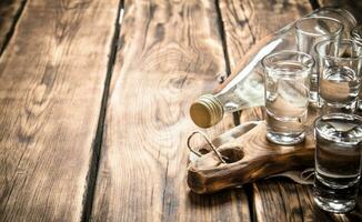 Wodka Flasche mit Schuss Brille auf das Tafel. foto