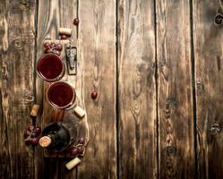 rot Wein auf hölzern Tafel mit Stopper und ein Korkenzieher. foto