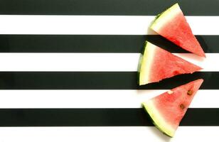 frisch rot Wassermelone Scheibe auf gestreift Hintergrund. Sommer- Konzept. oben Sicht, eben legen. - - Bild foto