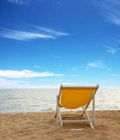 Strand Stuhl auf das Weiß Sand Strand mit wolkig Blau Himmel foto