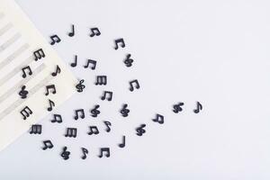 Musik- Blatt und Spiral- von schwarz Musical Anmerkungen auf ein Licht Hintergrund oben Aussicht foto