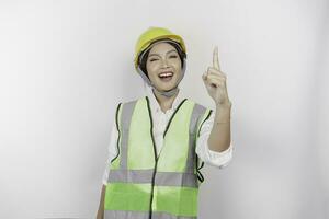 jung Frau Arbeit Lautsprecher tragen Sicherheit Helm und Weste gestikulieren Rede mit Hände isoliert auf Weiß Hintergrund. Arbeit Tag Konzept. foto