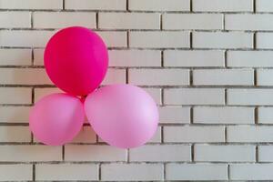 festlich rot Luftballons auf ein Backstein Mauer Hintergrund. Konzept Urlaub Geburtstag. foto