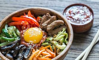 Schüssel von bibimbap auf das hölzern Tabelle foto