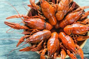 Schüssel von gekocht Flusskrebs auf das hölzern Tabelle foto