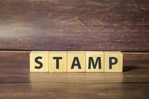 Wort Briefmarke gemacht mit hölzern Block und braun Hintergrund foto
