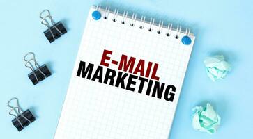 Weiß Notizblock mit Text Email Marketing und Büro Werkzeuge auf das Blau Hintergrund foto