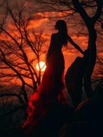 ein Frau im ein rot Kleid Stehen auf ein Felsen beim Sonnenuntergang generativ ai foto