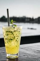 Orange Mojito-Sommer-Cocktail-Getränk auf einem Bartisch am Flussufer im Freien? foto