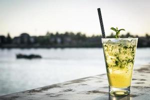 Orange Mojito-Sommer-Cocktail-Getränk auf einem Bartisch am Flussufer im Freien? foto