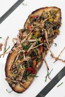 würziger getrockneter Tintenfisch und gebratenes Gemüse gerösteter offener Sandwich-Tapas-Snack in Portugal foto
