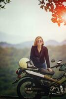 ziemlich Frau Stehen klein Enduro Motorrad gegen schön Berg scape beim khaoyai National Park Thailand foto
