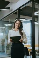 jung Frau mit Digital Tablette Stehen im das modern Büro foto