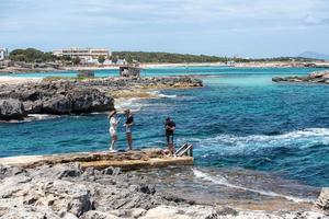 Junge Leute fotografieren am Strand von Es Pujols auf Formentera.