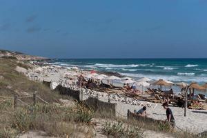 Leute, die die Sonne am Strand von Es arenals in Formentera, Spanien, genießen