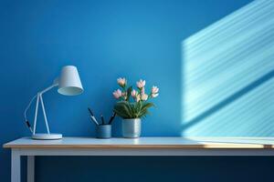 Tabelle mit Lampe, Pflanze und Griffe gegen ein Blau Mauer. Arbeitsplatz, Minimalismus. foto