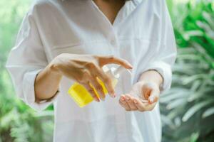 weiblich mit Alkohol Antiseptikum Gel zu Reinigung Hand foto