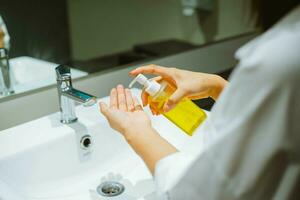weiblich mit Alkohol Antiseptikum Gel zu Reinigung Hand foto