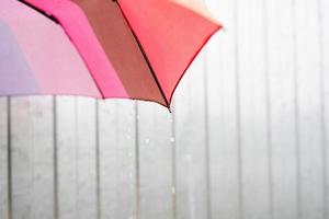 Nahaufnahme eines bunten Regenschirmteils mit Regentropfen