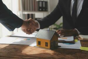 Immobilienmakler liefert dem Kunden ein Muster eines Musterhauses, Hypothekendarlehensvertrag, Leasing und Kauf und Verkauf von Haus- und Wohnungsversicherungs-Hypothekendarlehenskonzept foto