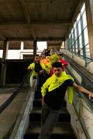 ein Gruppe von asiatisch Männer im Zitrone Grün Jacken sind Stehen mit ihr freunde auf das Rolltreppe foto