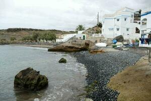 ein Strand mit Felsen und ein Haus auf das Ufer foto