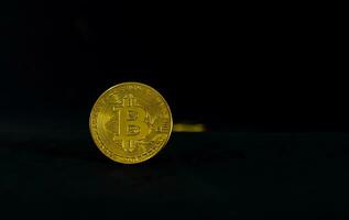 golden Bitcoin, Bitcoin mit dunkel schwarz Hintergrund foto