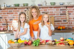 Mutter und Töchter Kochen zusammen im das Küche. gesund Essen Konzept. Porträt von glücklich Familie mit frisch Smoothies. glücklich Schwestern. foto