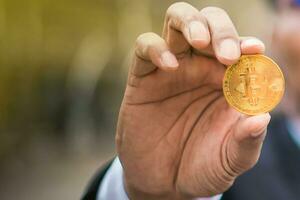 golden Bitcoin im Geschäftsmann Hand, Bokeh, Morgen Licht lila Hintergrund. foto