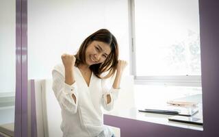 schön asiatisch Geschäftsfrau posieren mit Freude im ihr Büro. foto