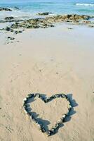 ein Herz gestalten auf das Strand foto