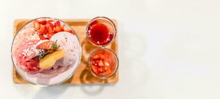 das Rosa Eis Sahne im ein Tasse ist platziert auf ein Weiß Tabelle beim ein Eis Sahne Geschäft im Sommer. schließen hoch, selektiv Fokus, Kopieren Raum auf richtig zum Design oder Inhalt. verschwommen Hintergrund foto