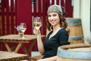 schön jung Frau Trinken Weiß Wein auf das Terrasse von ein Restaurant. entspannend nach Arbeit mit ein Glas von Wein. Single Frau haben Spaß. foto