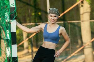 sportlich jung Frau im Sportbekleidung tun Dehnen Übungen draußen. Porträt von ein jung Mädchen tun Sport im das Park. foto