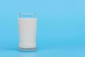 Welt Milch Tag, ein Glas von Weiß Milch isoliert auf ein Blau Hintergrund, schließen hoch. glücklich Milch Tag. Molkerei Produkt Konzept, Kopieren Raum auf richtig zum Design oder Inhalt, niemand, Welt Milch Tag 1 Juni foto