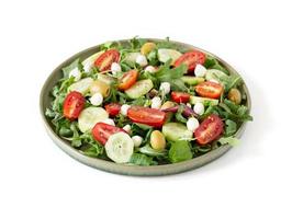 Salat mit Rucola, Tomaten, Gurken, Mozzarella und Oliven foto