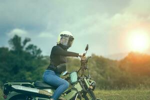 Frau tragen Sicherheit Helm Reiten klein Enduro Motorrad gegen schön Hintergrund foto