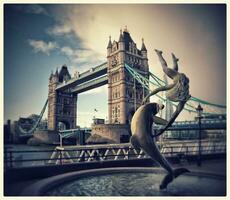 ikonisch Aussicht von Turm Brücke mit Delfin Statue und jung Meerjungfrau, London, Vereinigtes Königreich foto