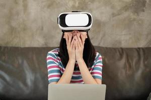 asiatische Frau mit VR-Headset, die die virtuelle 3D-Simulation beobachtet.