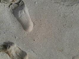Fußabdruck texturiert von Mensch Füße auf das Sand Küsten foto