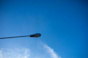 elektrisch Licht Birne auf das Seite von das Straße über ist das Blau Himmel. foto