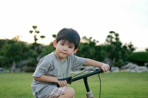 asiatisch Junge spielen Fahrrad im das Park foto