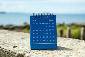 Blau August 2024 Kalender auf verschwommen Hintergrund von Blau Ozean. foto