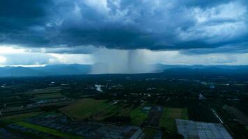 Antenne Panorama- Aussicht von Gemeinschaft und Ackerland mit enorm Sturm Wolken im das Hintergrund. Antenne Aussicht von das Regen Über ein ländlich Gemeinschaft. Regen Wolken Schuss von ein Drohne. foto