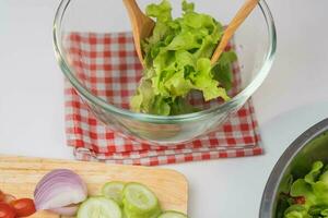 Kochen - - Frau Herstellung frisch organisch Gemüse Salat im das Küche. weiblich Hände vorbereiten köstlich gesund Essen beim heim, Mischen Gemüse im ein Schüssel, Nahaufnahme. foto