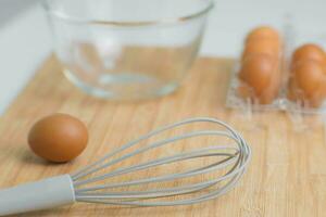 frisch organisch Eier mit Küche Utensilien auf hölzern Hintergrund. Koch im das Küche. vorbereiten Frühstück von Bauernhof Produkte, natürlich Eier. foto