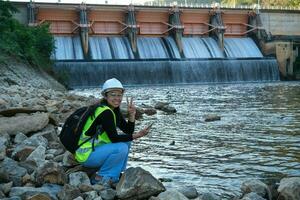 Umwelt Ingenieur Verwendet ein Handy, Mobiltelefon Telefon zu Aufzeichnung Wasser Analyse Daten im Damm. Umweltschützer sammeln Wasser Proben von das Damm zu prüfen zum Kontamination. Wasser und Ökologie Konzept foto